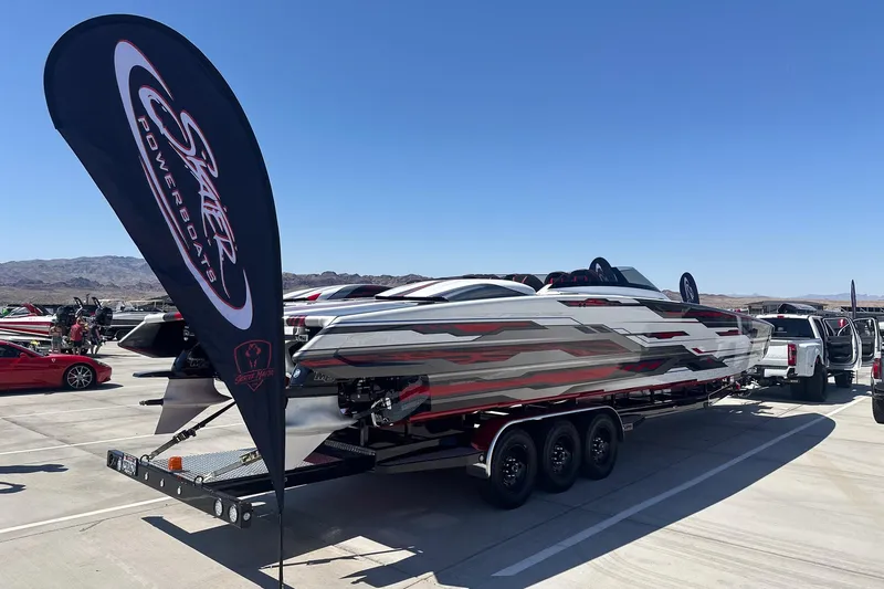 Slide: The Image of 2024 Skater 368 powerboat on trailer, displayed outdoors with branded flag. - 38