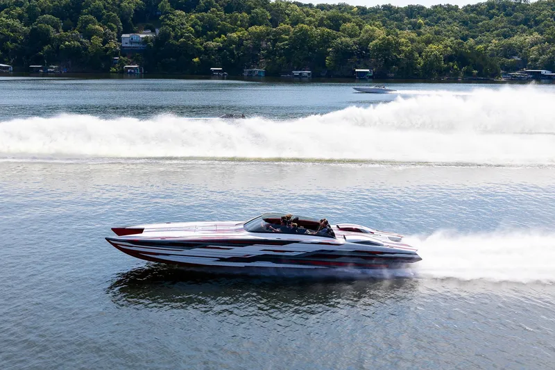 Slide: The Image of 2024 Skater 368 speedboat racing on a lake with lush green shoreline. - 37