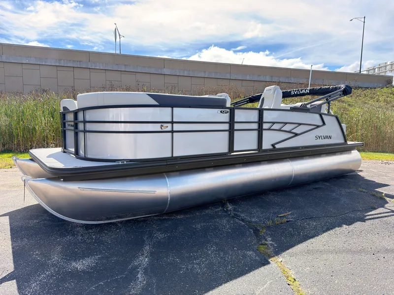 Slide: The Image of The image shows a 2027 Sylvan Q-22 ULZ pontoon boat parked on a lot. - 0