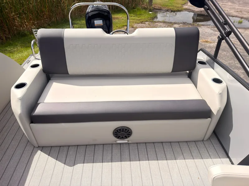 Slide: The Image of The image shows a bench seat on a 2027 Sylvan Q-22 ULZ boat. The upholstery is two-toned, with built-in cup holders and a speaker below. - 42