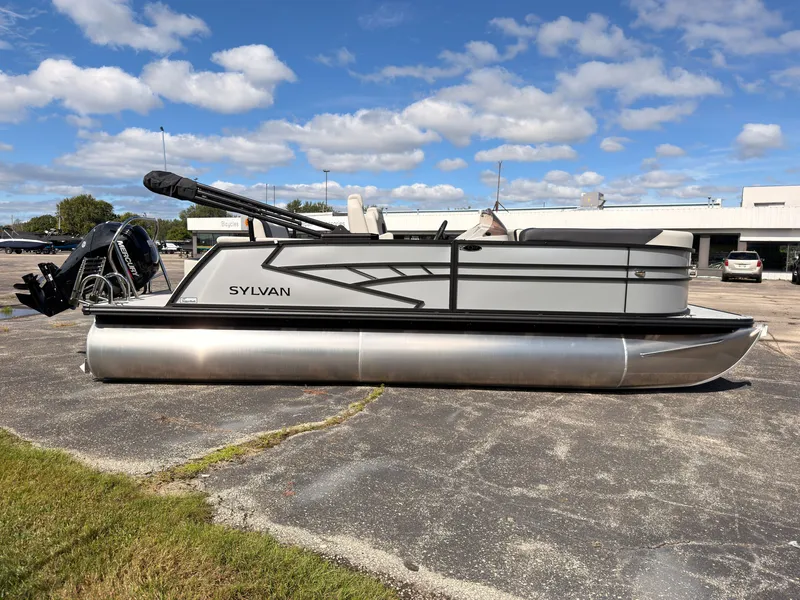 Slide: The Image of A modern Sylvan Q-22 ULZ pontoon boat from 2027 sits in a parking lot under a blue sky. - 7