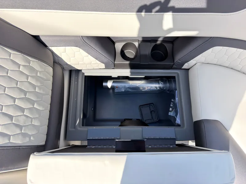 Slide: The Image of The 2027 Sylvan Q-22 ULZ features an open storage compartment with two cup holders and cushioned seats. - 21