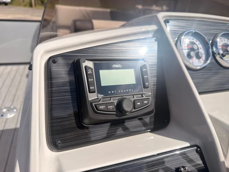 Slide: The Image of The image shows the dashboard of a Sylvan Q-22 ULZ boat with a sound system and gauges. - 32