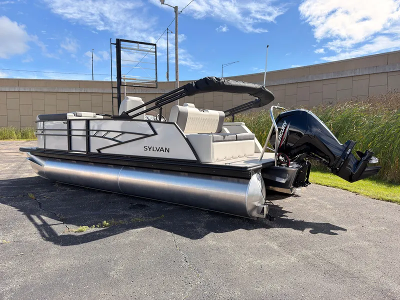 Slide: The Image of A 2027 Sylvan Q-22 ULZ pontoon boat is parked on a lot. It features white seating and an outboard motor. - 4
