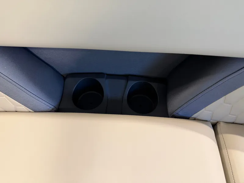 Slide: The Image of Close-up of two cup holders between beige and blue upholstery on a boat. - 7