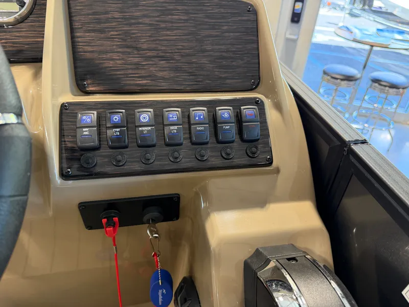 Slide: The Image of The image shows the dashboard of a Sylvan Q-22 ULZ boat with various switches. - 21