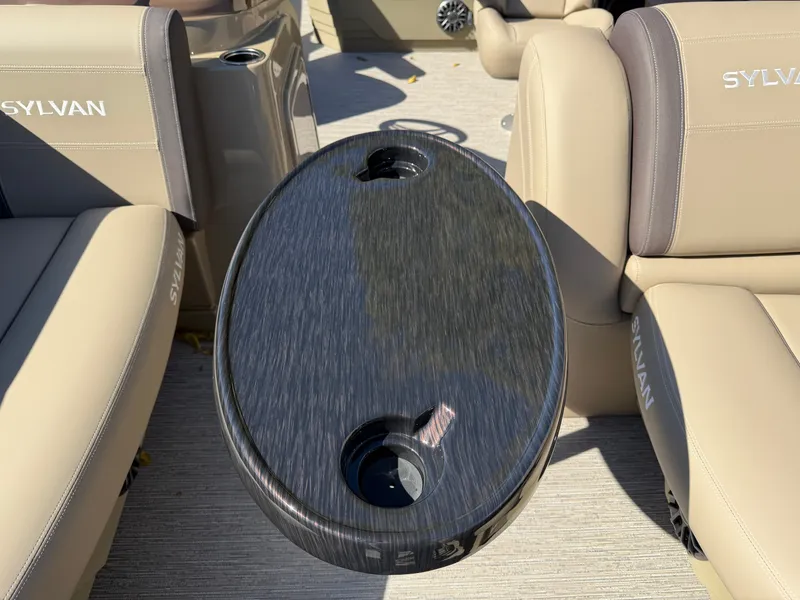 Slide: The Image of A sleek table with cup holders in a Sylvan boat, surrounded by beige seating. - 5