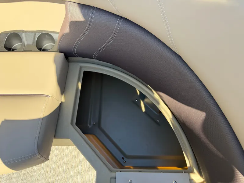 Slide: The Image of Close-up of a seating area with storage compartment and cup holders on a Sylvan MIRAGE 822 CLZ DH boat. - 11