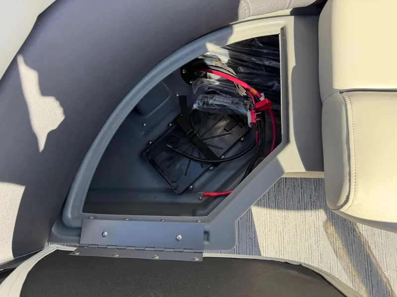 Slide: The Image of An open storage compartment in a Sylvan Mirage 822 LZ boat, showing cables and brackets. - 25