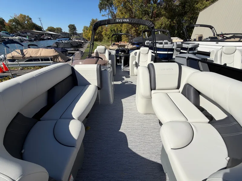 Slide: The Image of The image shows the spacious interior of a Sylvan Mirage 822 LZ pontoon boat with sleek seating. - 4