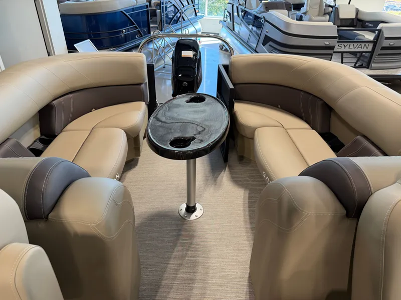Slide: The Image of The image shows the interior of a 2027 Sylvan Mirage 822 LZ with beige leather seating and a small table. - 25