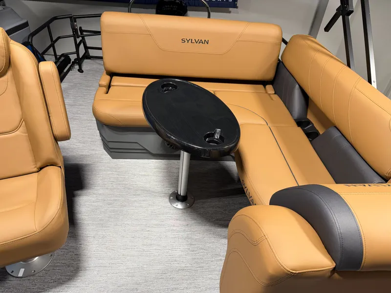 Slide: The Image of The image shows the interior of a 2027 Sylvan Mirage 822 CLZ with beige leather seating and a small table. - 18