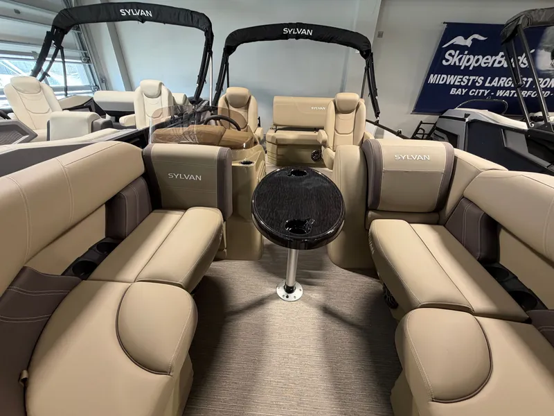 Slide: The Image of The image shows the interior of a 2027 Sylvan Mirage 820 CLZ DH with beige seating and a table. - 2