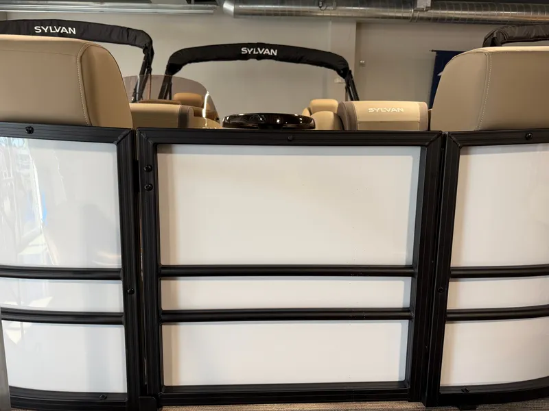 Slide: The Image of The image shows the interior of a Sylvan Mirage 820 CLZ DH pontoon boat with beige seats. - 1