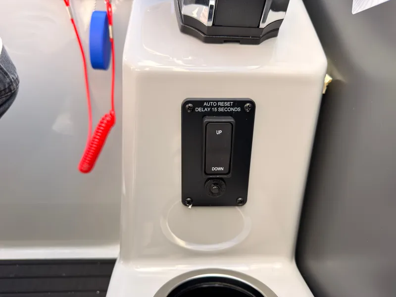 Slide: The Image of Close-up of a boat panel with an auto reset switch and a cup holder. - 42