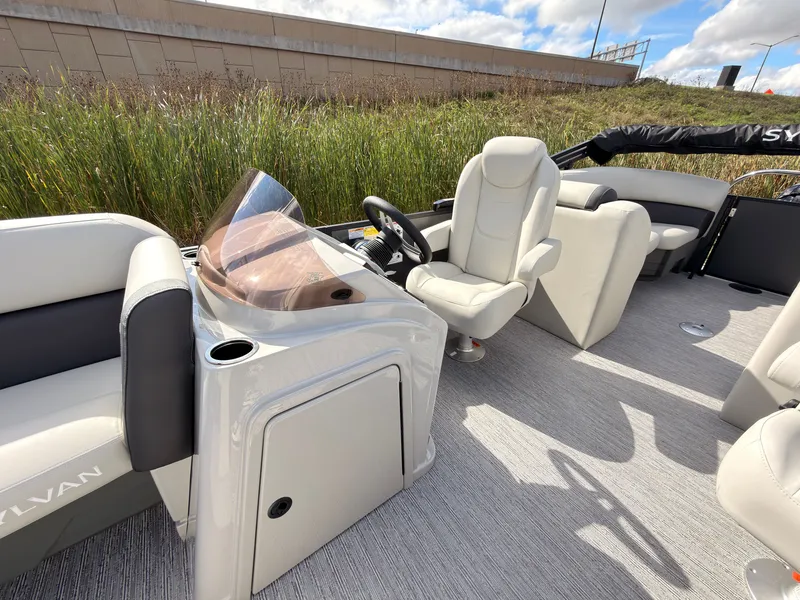 Slide: The Image of The image shows the cockpit of a 2027 Sylvan Mirage 822 LZ with beige seating and a modern helm. - 33