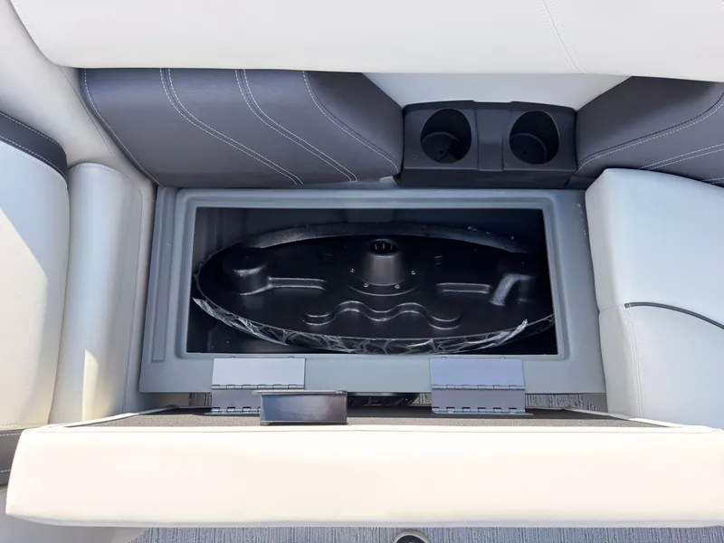 Slide: The Image of An open storage compartment with a round black object inside, surrounded by cushioned seating. - 49