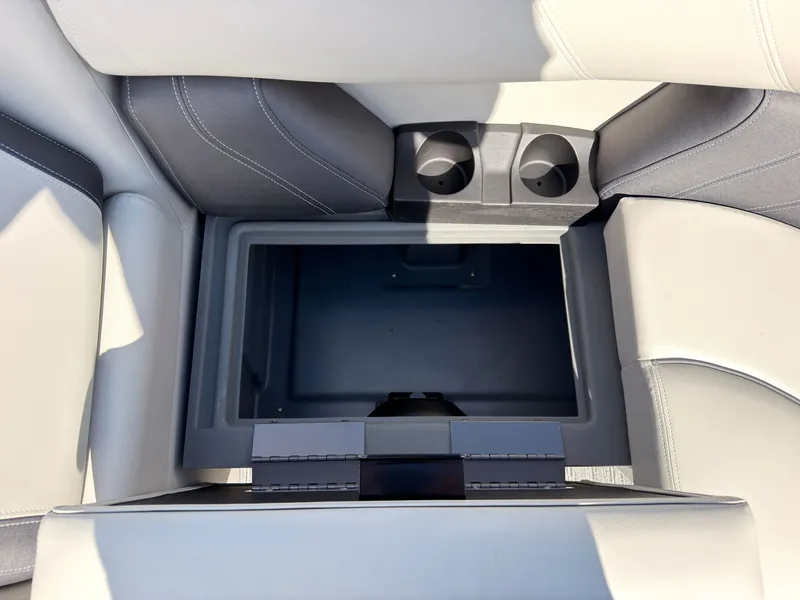 Slide: The Image of An open storage compartment with two cup holders in a Sylvan Mirage 822 LZ boat. - 23