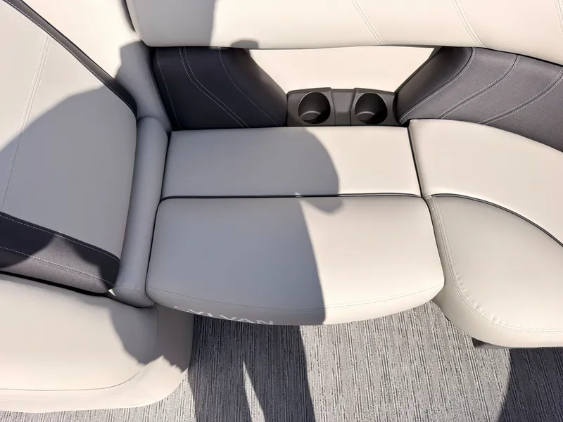 Slide: The Image of Light-colored cushioned seating with two cup holders in the center, on a boat. - 22