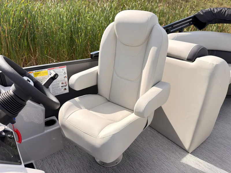Slide: The Image of A luxurious, padded captain's chair on a Sylvan Mirage 822 LZ boat, surrounded by reeds. - 34
