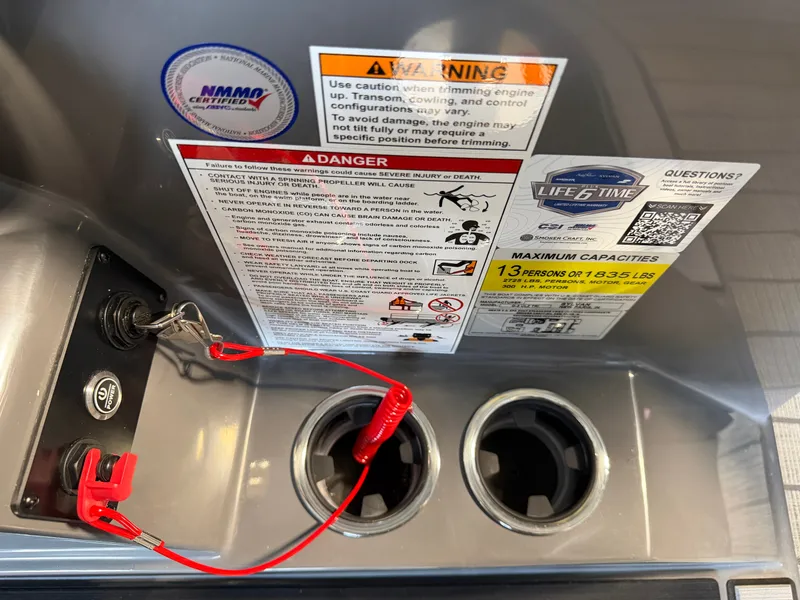 Slide: The Image of Close-up of a boat control area with warning labels and cup holders. - 28
