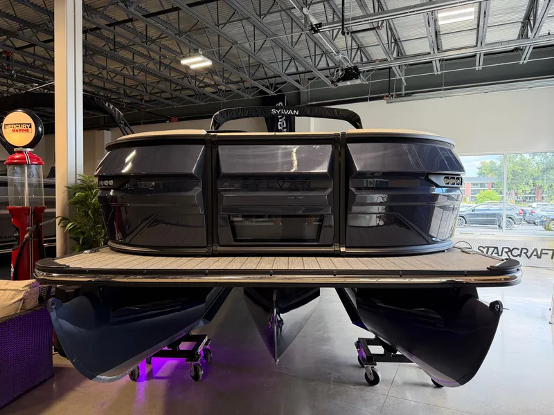 Slide: The Image of A 2027 Sylvan G-3 ULZ pontoon boat is displayed in a showroom with modern features. - 2
