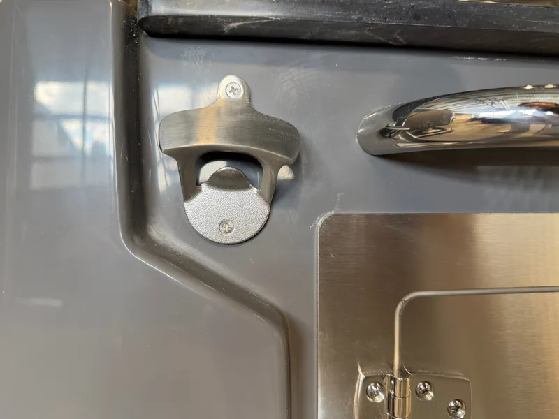 Slide: The Image of A bottle opener is mounted on a gray wall, next to a shiny handle. - 33