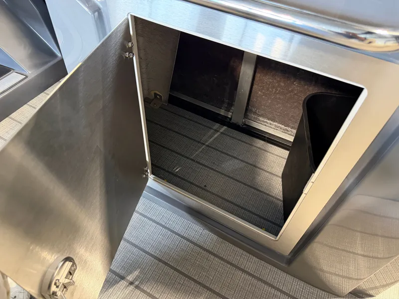 Slide: The Image of An open storage compartment with a metal door on a boat. - 32