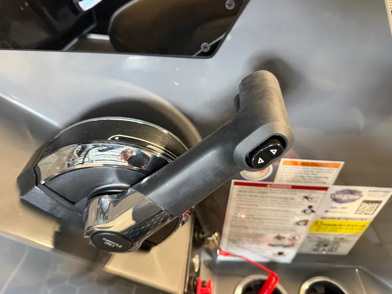 Slide: The Image of Close-up of a boat throttle lever with warning labels and controls. - 27