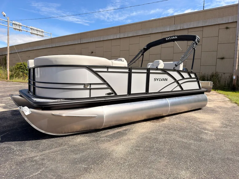 Slide: The Image of A modern pontoon boat with a silver hull and white seating, parked on an asphalt lot. - 8