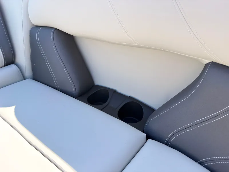 Slide: The Image of Close-up of a boat seat with gray and white upholstery and built-in cup holders. - 22