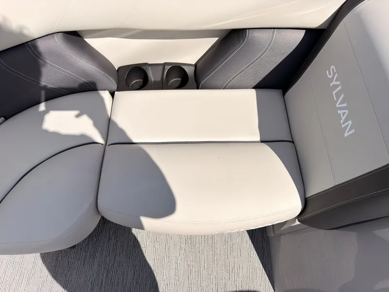 Slide: The Image of The seating area of a Sylvan Mirage 820 CLZ DH with beige upholstery and cup holders. - 14