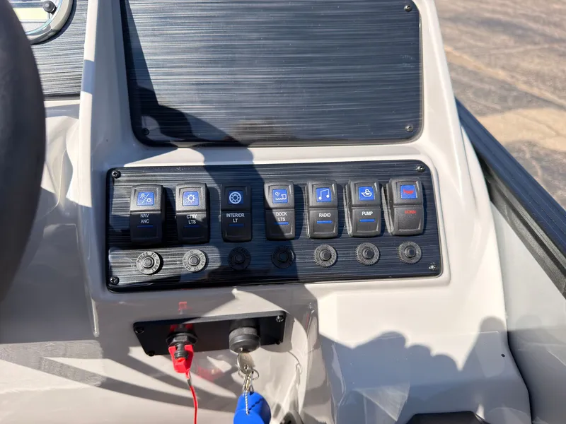 Slide: The Image of The image shows the dashboard of a Sylvan Mirage 820 CLZ DH boat with various switches and indicators. - 36