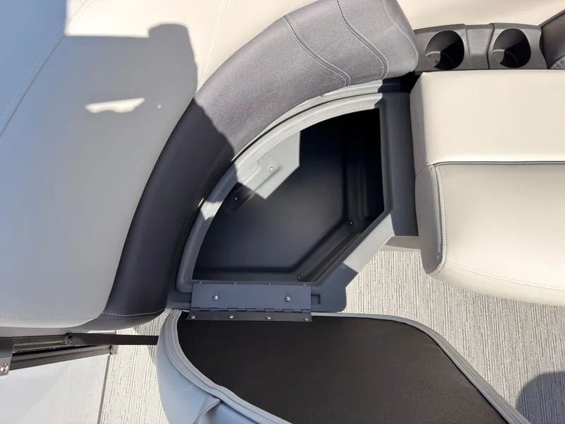 Slide: The Image of An open storage compartment on a Sylvan Mirage 820 CLZ DH boat, surrounded by cushioned seating. - 13