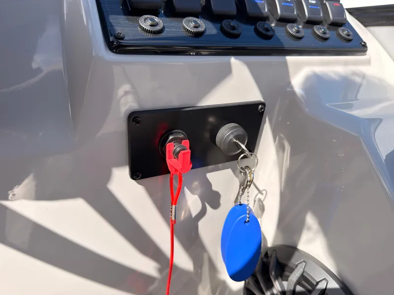 Slide: The Image of Close-up of a boat ignition switch with a red safety lanyard and a blue key fob. - 37