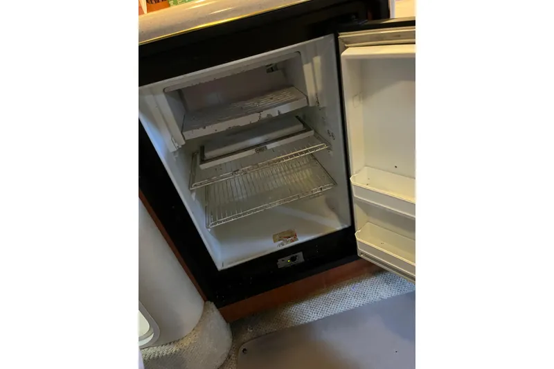 Slide: The Image of Open refrigerator inside a 2001 Sea Ray 340 Sundancer boat, showing empty shelves. - 22
