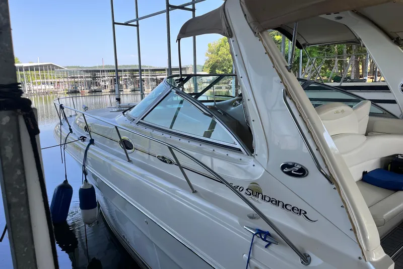 Slide: The Image of 2001 Sea Ray 340 Sundancer docked at marina, showcasing sleek design and comfortable seating. - 2