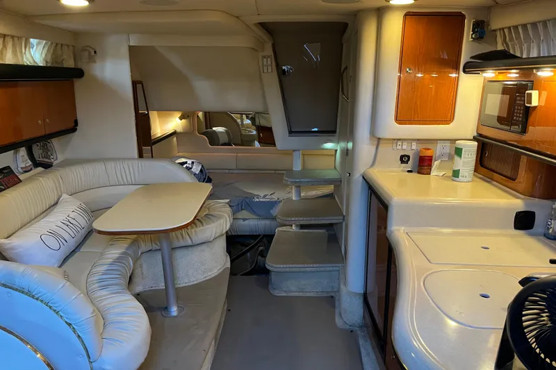 Slide: The Image of Interior of 2001 Sea Ray 340 Sundancer yacht with cozy seating and kitchenette. - 23