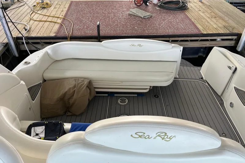 Slide: The Image of 2001 Sea Ray 340 Sundancer boat interior with white seating and dock view. - 12