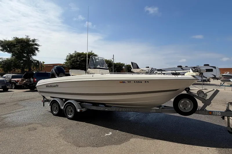 Slide: The Image of 2005 Wellcraft 200 LT Fisherman boat on trailer in parking lot under clear sky. - 1