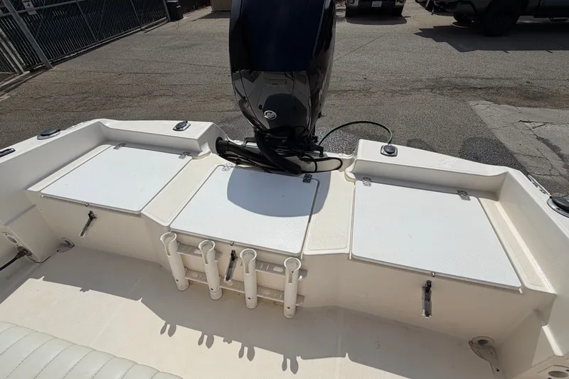 Slide: The Image of 2005 Wellcraft 200 LT Fisherman boat deck with storage compartments and motor. - 19