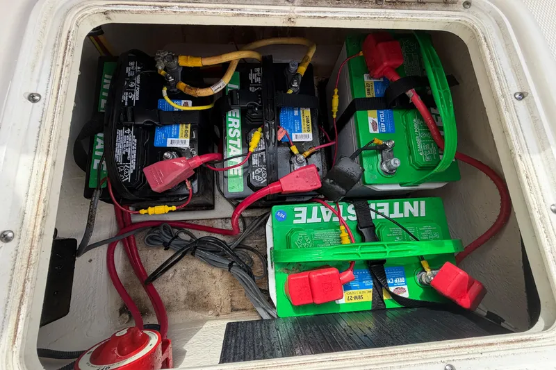 Slide: The Image of Battery compartment of a 2005 Wellcraft 200 LT Fisherman boat, featuring multiple Interstate batteries. - 25