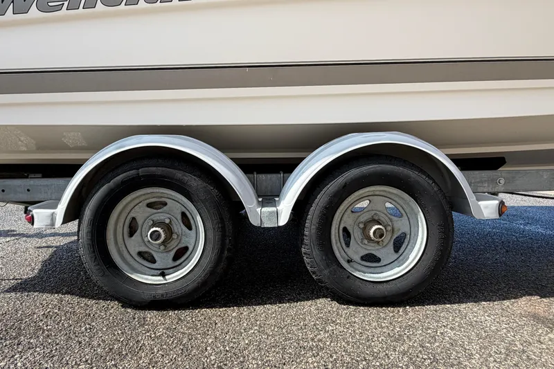 Slide: The Image of Trailer wheels of a 2005 Wellcraft 200 LT Fisherman boat on asphalt. - 7