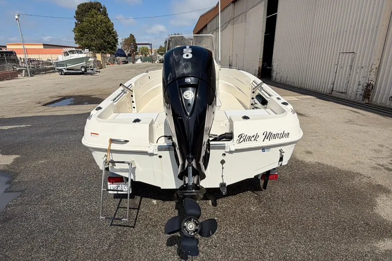 Slide: The Image of 2005 Wellcraft 200 LT Fisherman boat named "Black Mamba" with outboard motor, parked outdoors. - 4