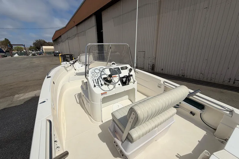 Slide: The Image of 2005 Wellcraft 200 LT Fisherman boat, white interior, docked near a large warehouse. - 9