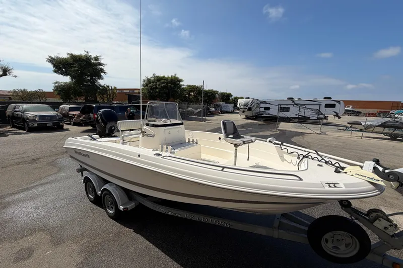 Slide: The Image of 2005 Wellcraft 200 LT Fisherman boat on trailer in parking lot under clear sky. - 2