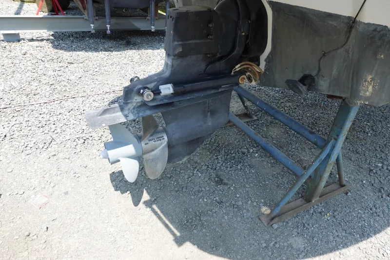 Slide: The Image of 2004 Crownline 240 EX boat propeller and outdrive on gravel surface. - 10