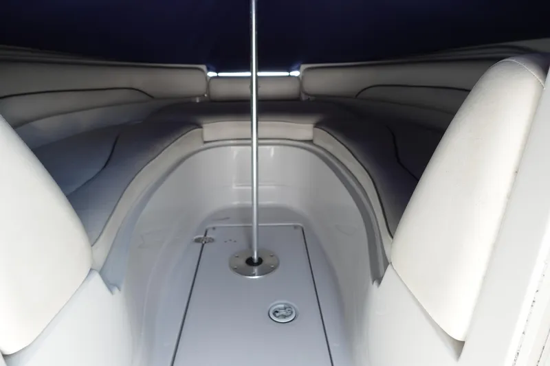 Slide: The Image of Interior view of a 2004 Crownline 240 EX boat, featuring cushioned seating and a central pole. - 6