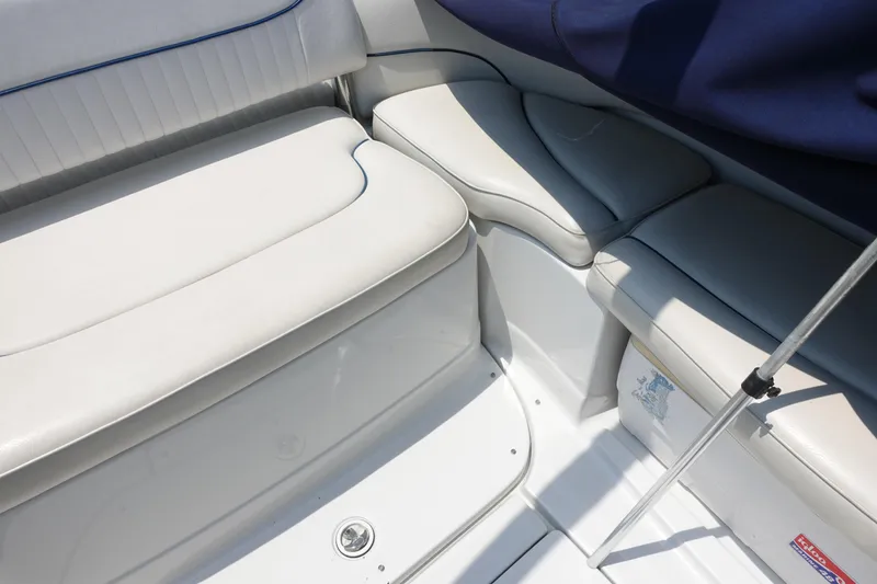 Slide: The Image of 2004 Crownline 240 EX boat interior with white cushioned seating and blue accents. - 8