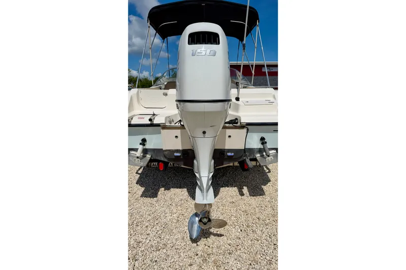 Slide: The Image of 2016 Key West 203 DFS boat with outboard motor, parked on gravel. - 33